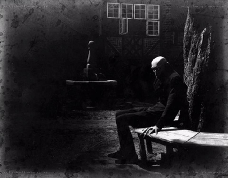 man sitting in dark courtyard