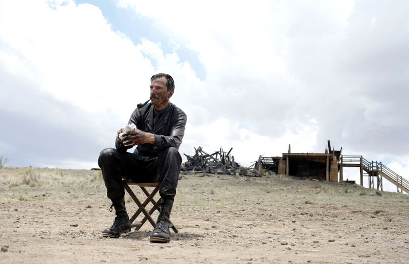 man sitting in desolate landscape