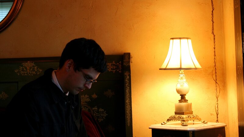 Man Sitting in Dim Light — Yellow