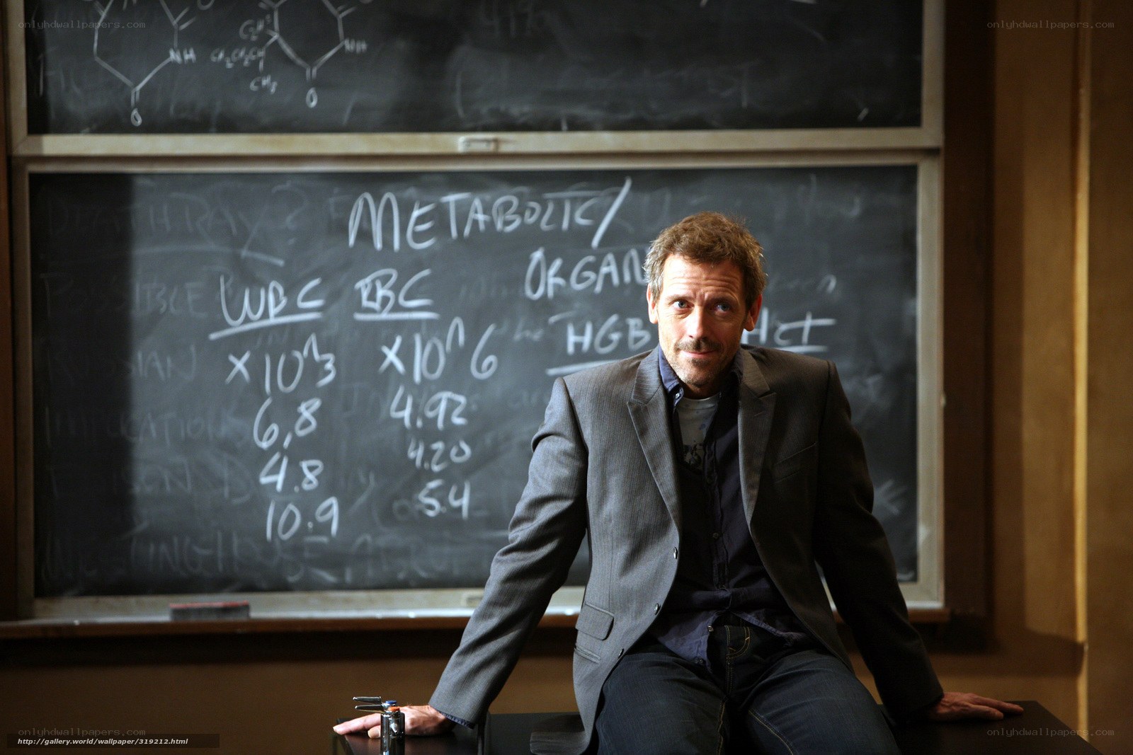 man sitting in front of chalkboard