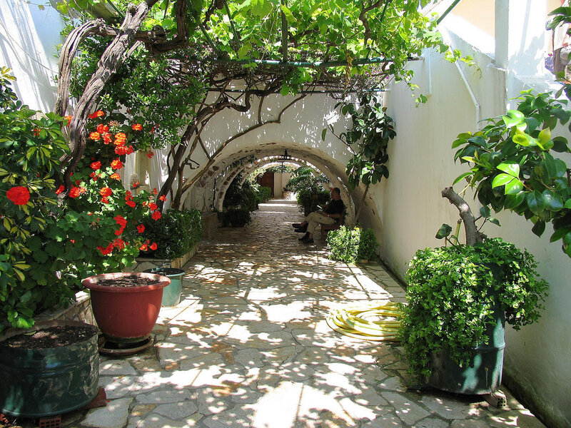 Man Sitting in Garden Corridor