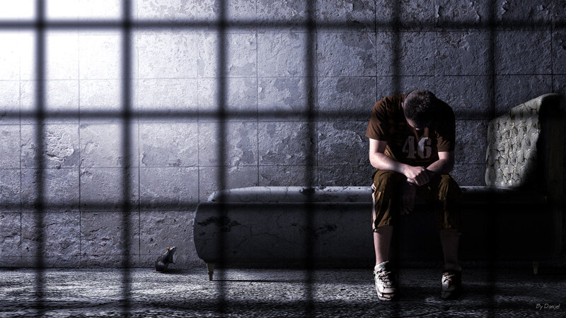 Man Sitting in Prison Cell