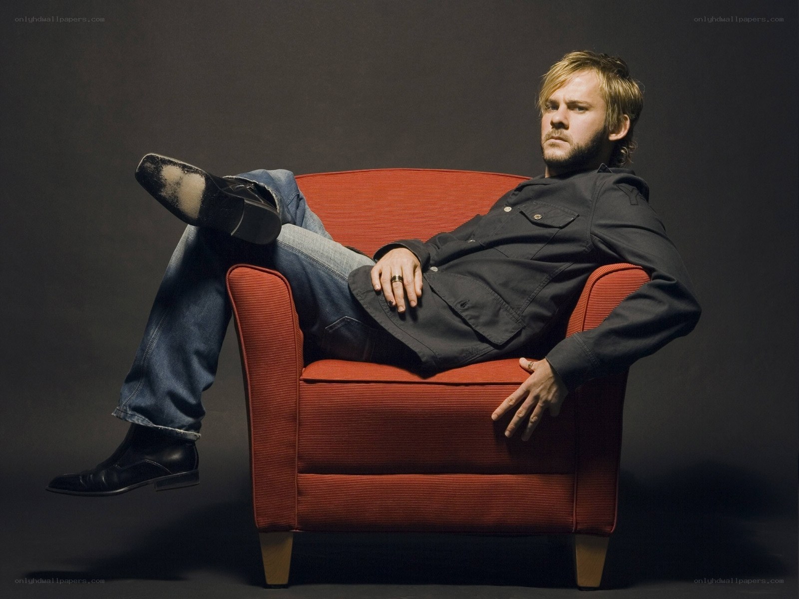 man sitting in red armchair