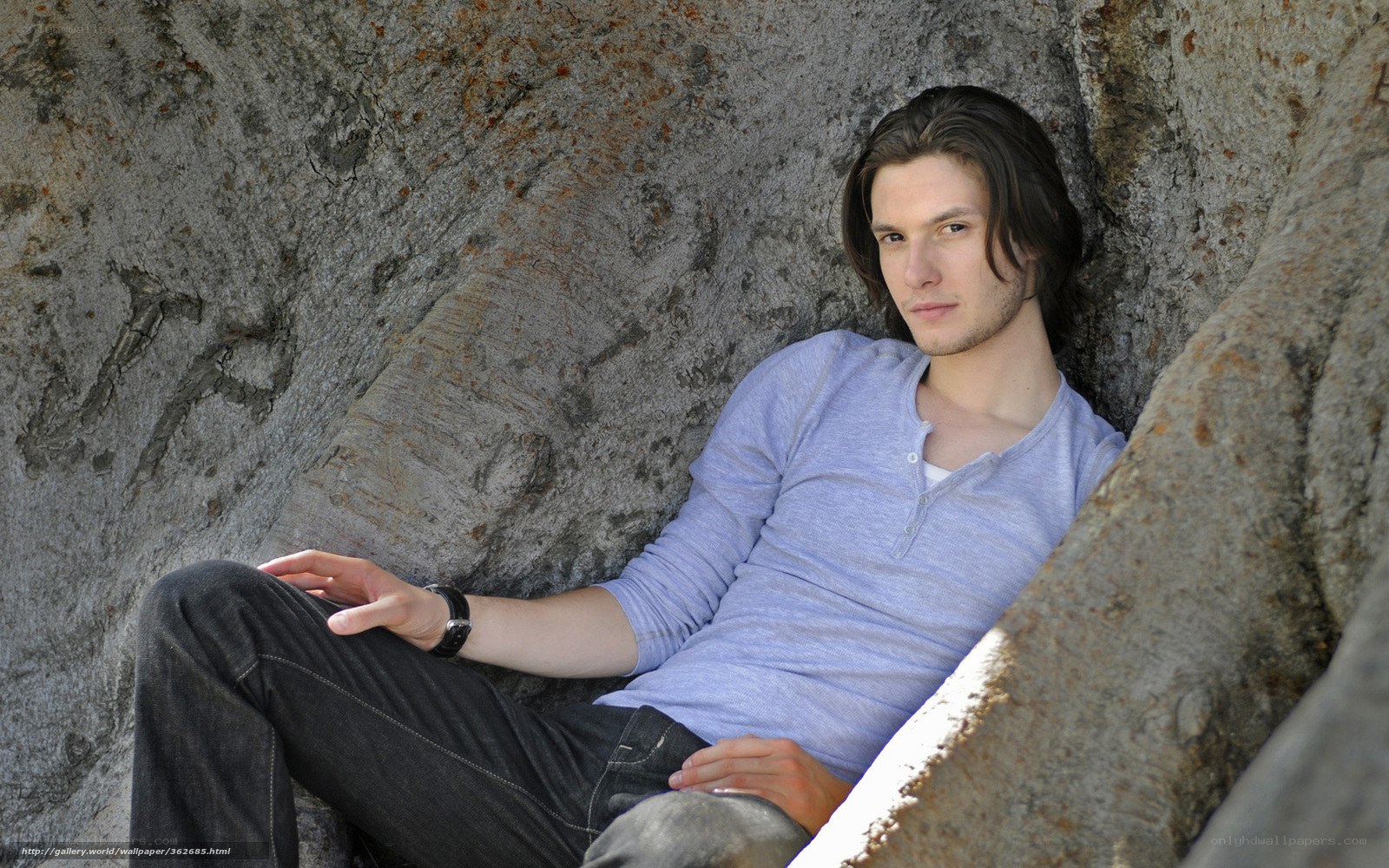 man sitting in rock crevice
