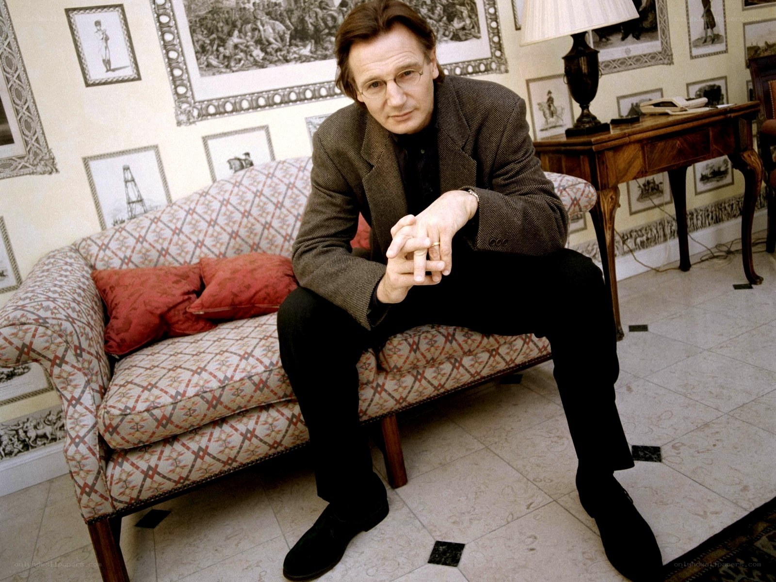 man sitting on a patterned sofa