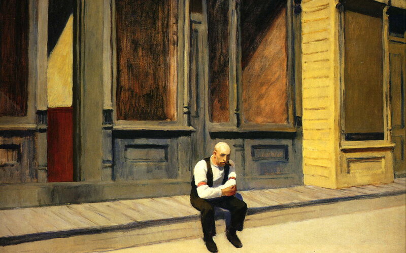 Man sitting on a sidewalk