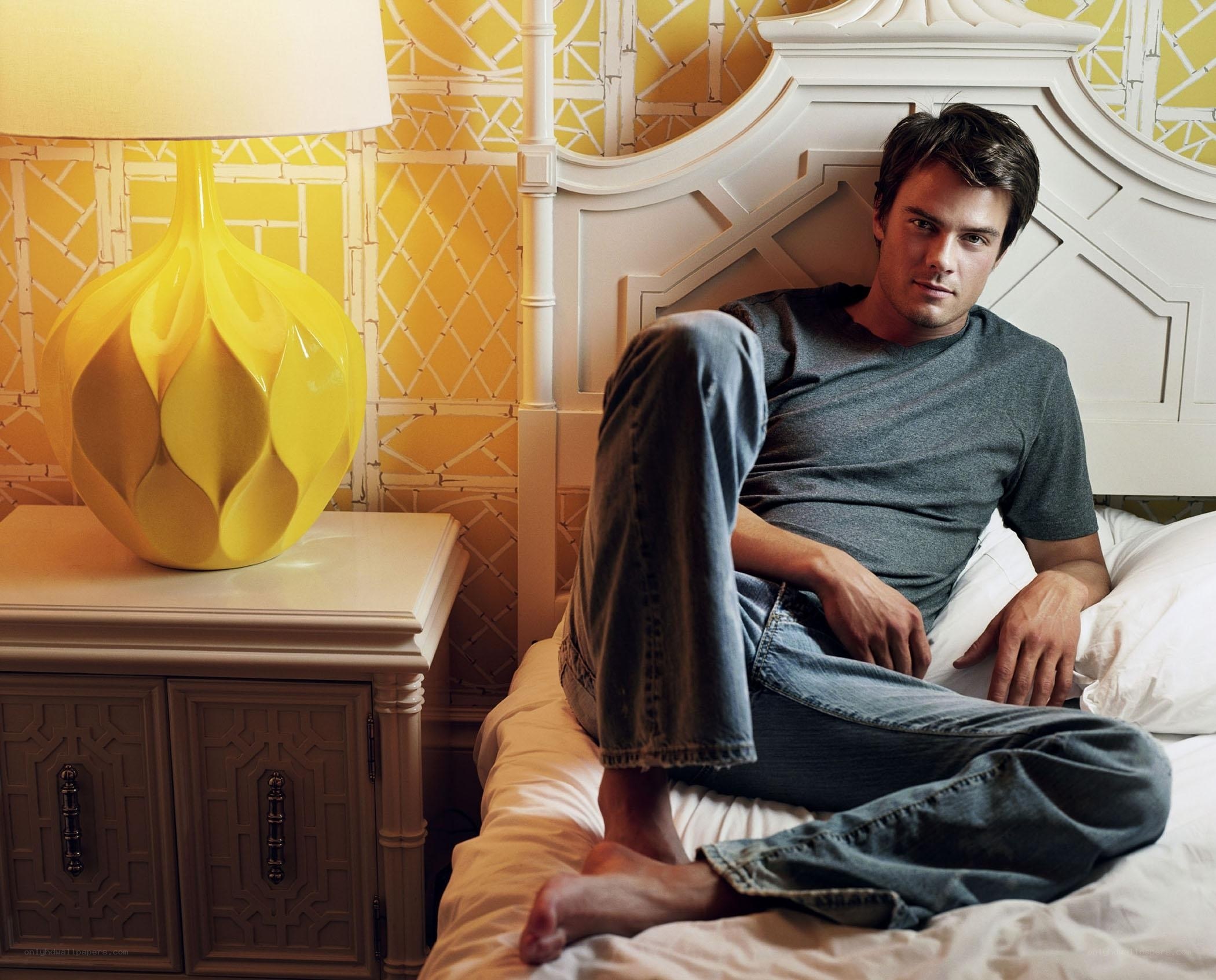 man sitting on bed in bedroom