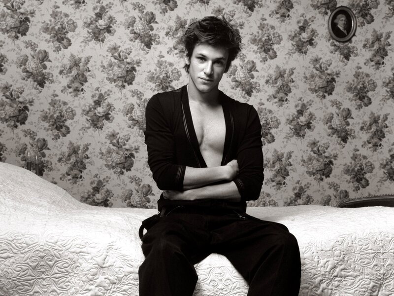 man sitting on bed in black shirt