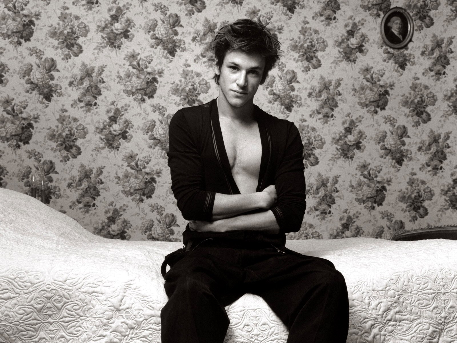 man sitting on bed in black shirt