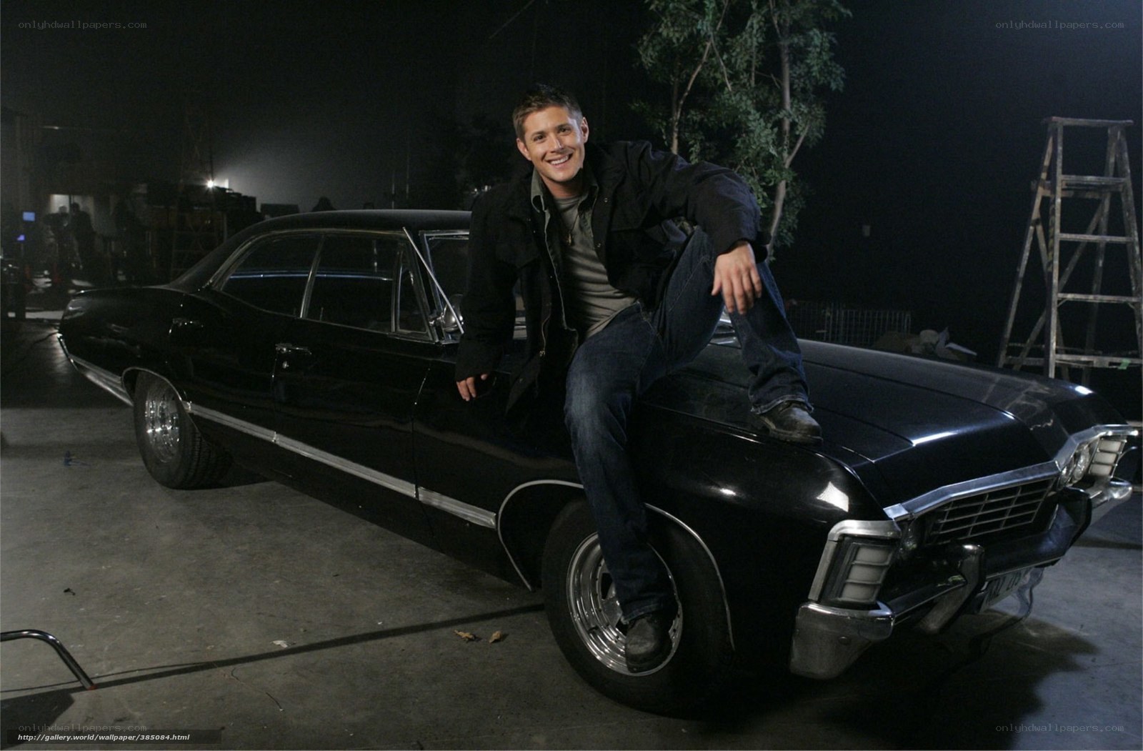 man sitting on black car