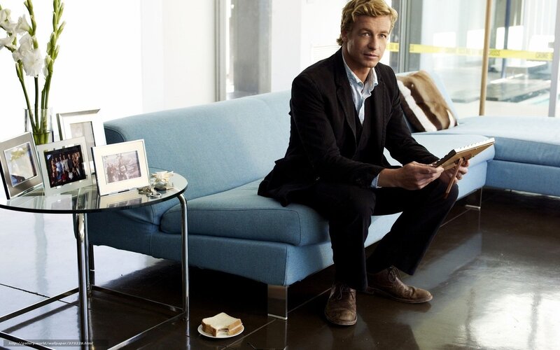 Man sitting on blue couch with tablet