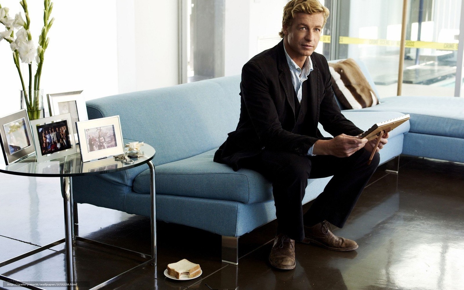 Man sitting on blue couch with tablet