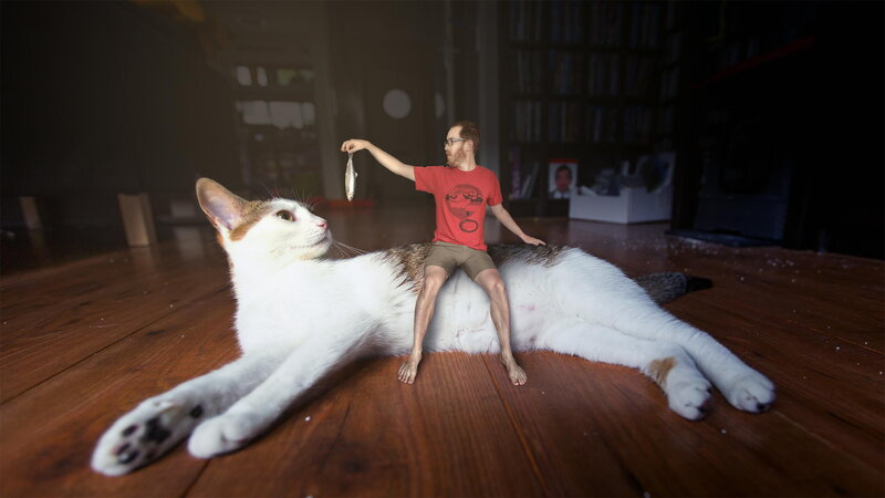Man Sitting on Cat