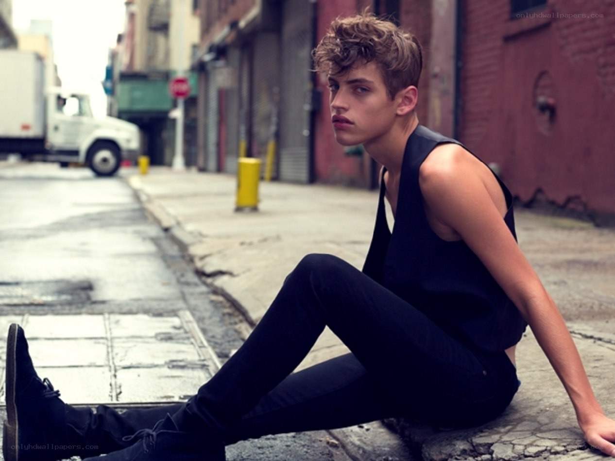man sitting on city sidewalk