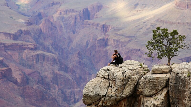 Man Sitting on Cliff — Brown
