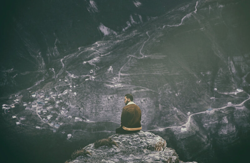 Man Sitting on Cliff — Green, Contemplative