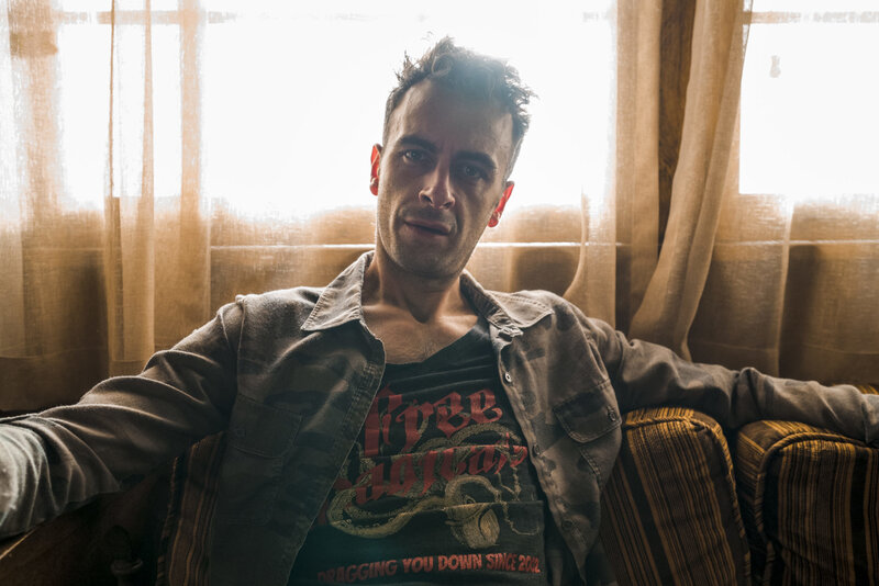 Man Sitting on Couch — Brown, Dramatic, Afternoon