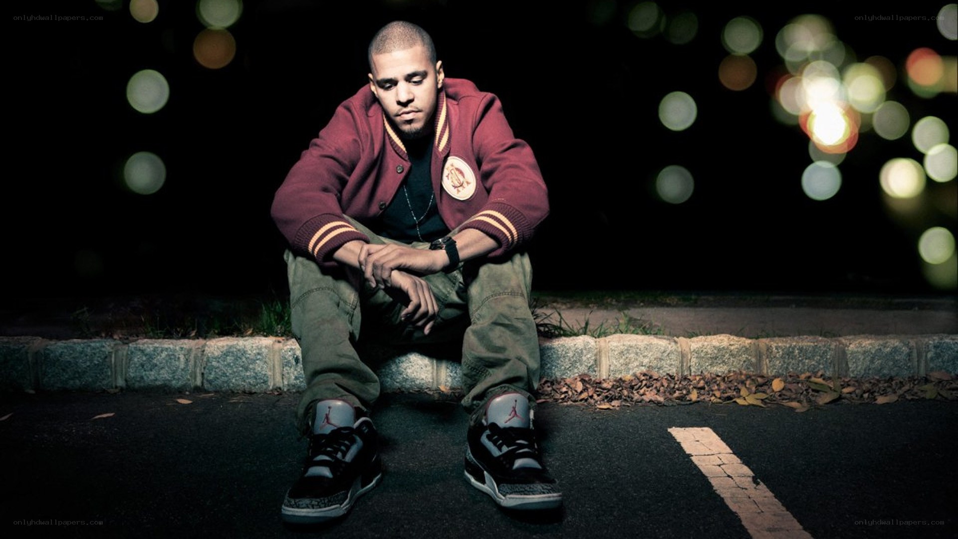 man sitting on curb at night