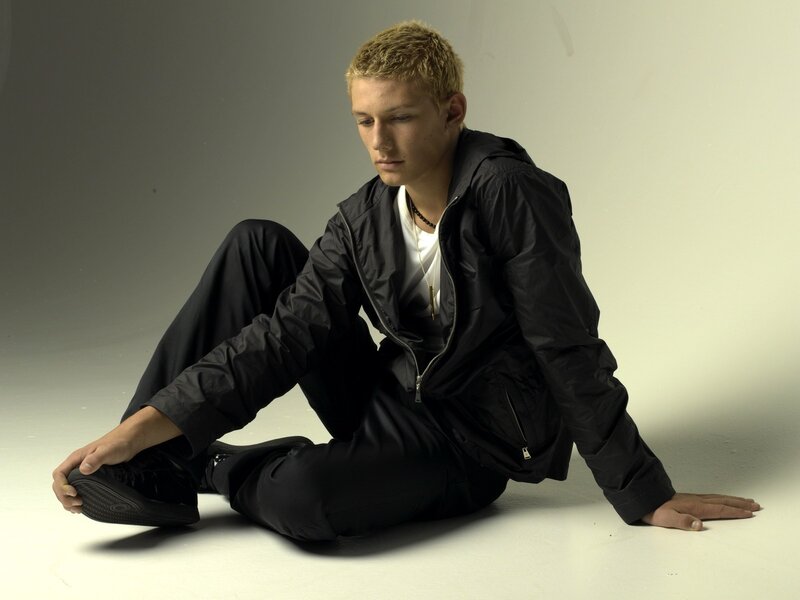 man sitting on floor in black jacket