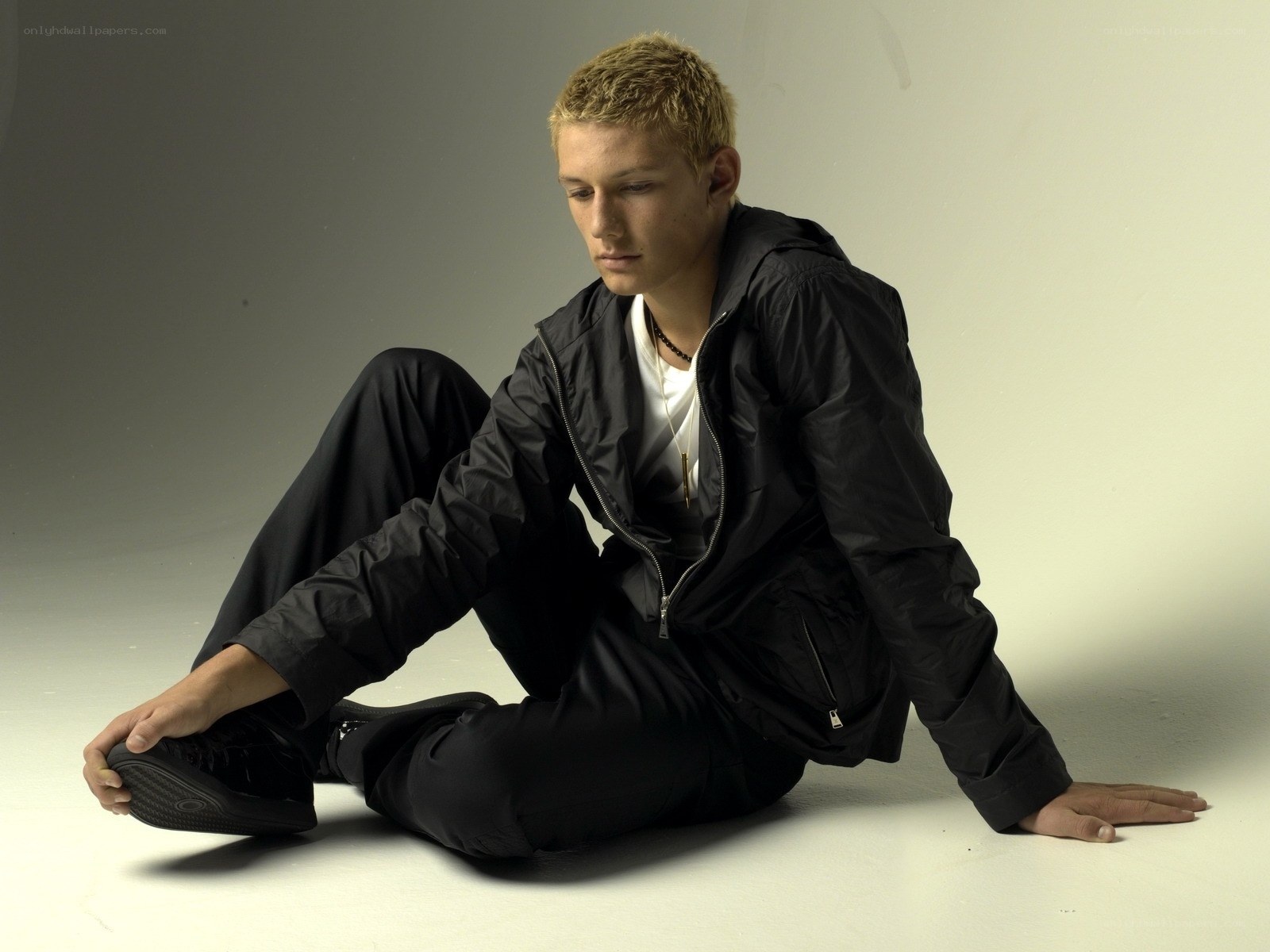 man sitting on floor in black jacket