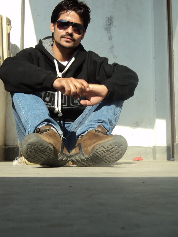 man sitting on ground wearing sunglasses