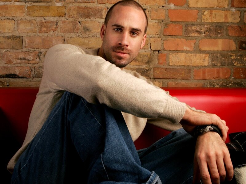 Man Sitting on Red Couch — Relaxed