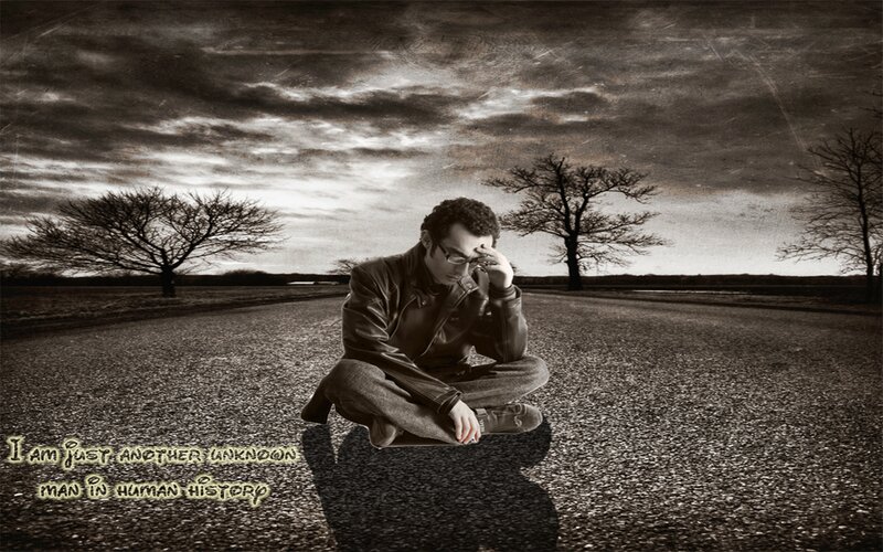 man sitting on road at dusk
