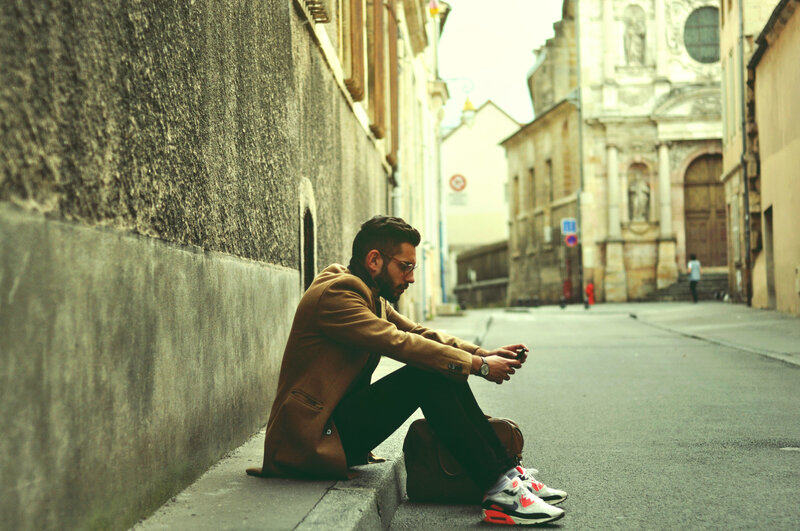 Man Sitting on Sidewalk — Brown
