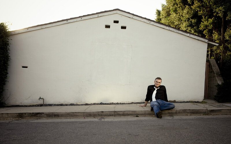 man sitting on sidewalk