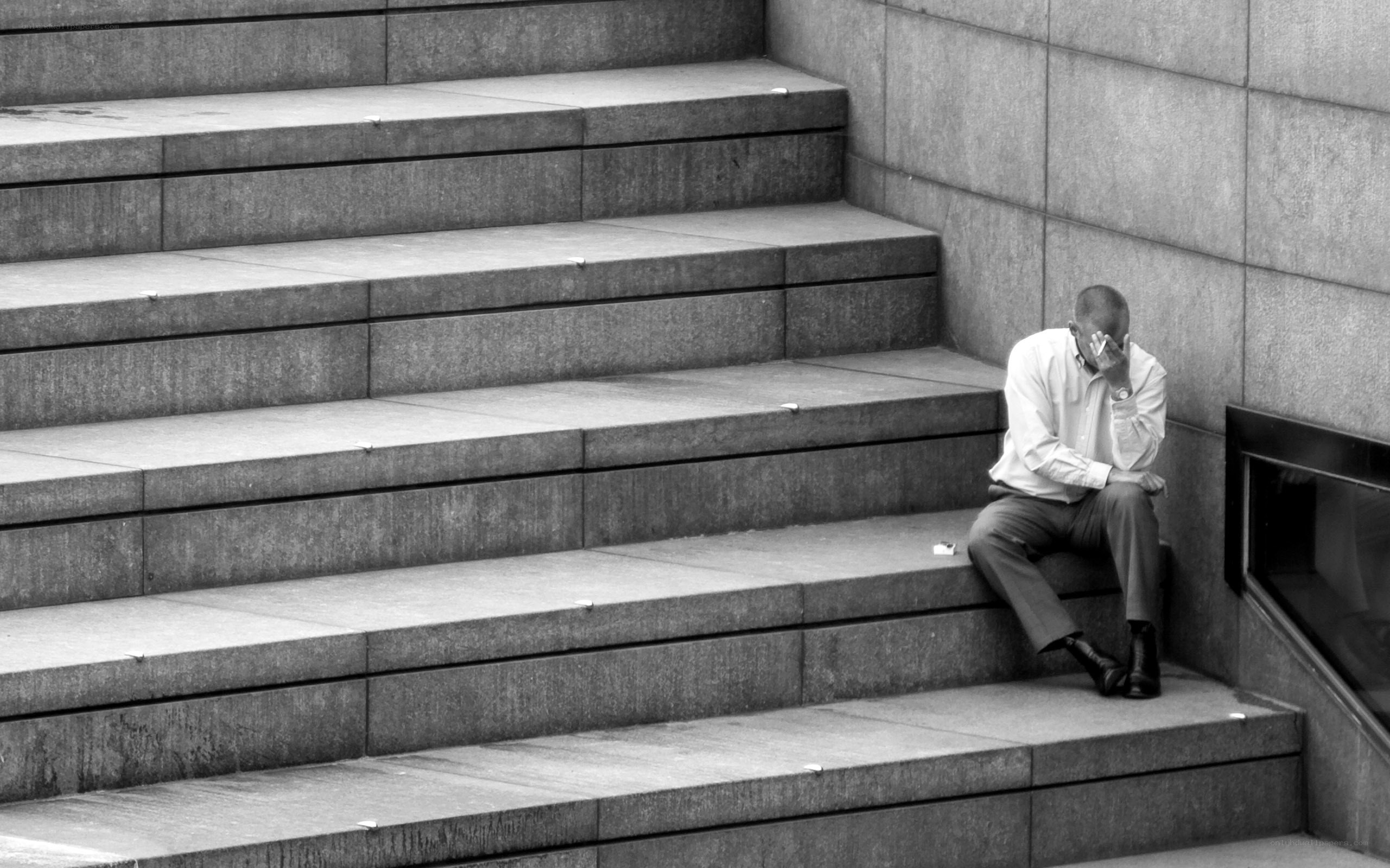 man sitting on steps in distress