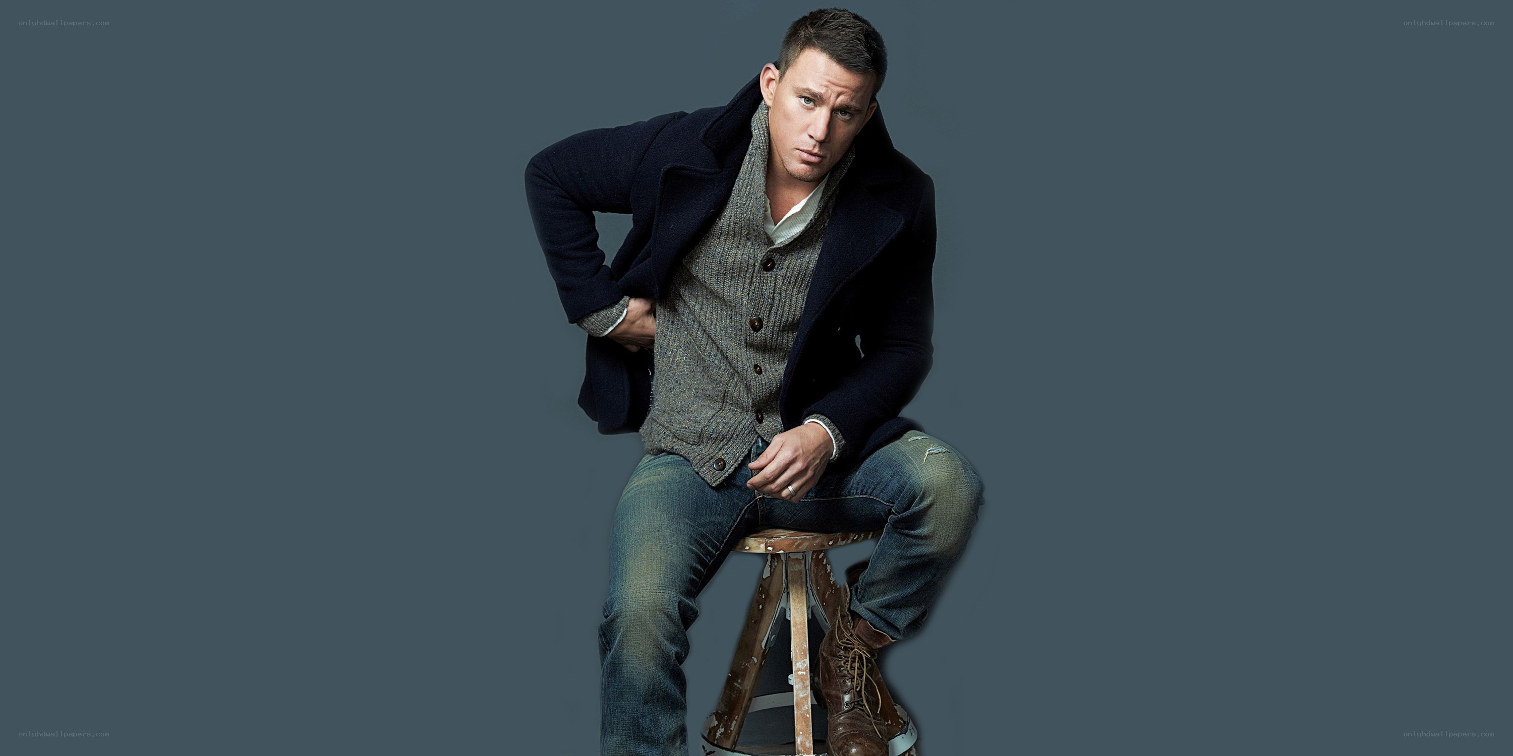 man sitting on stool in coat