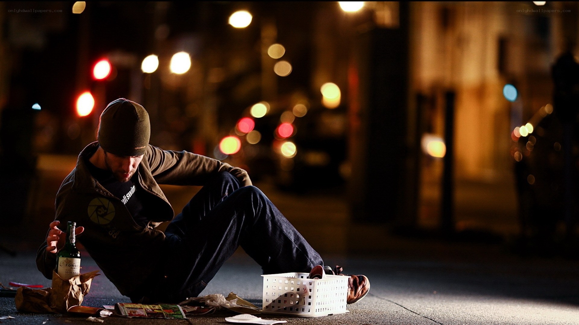 Man sitting on street at night