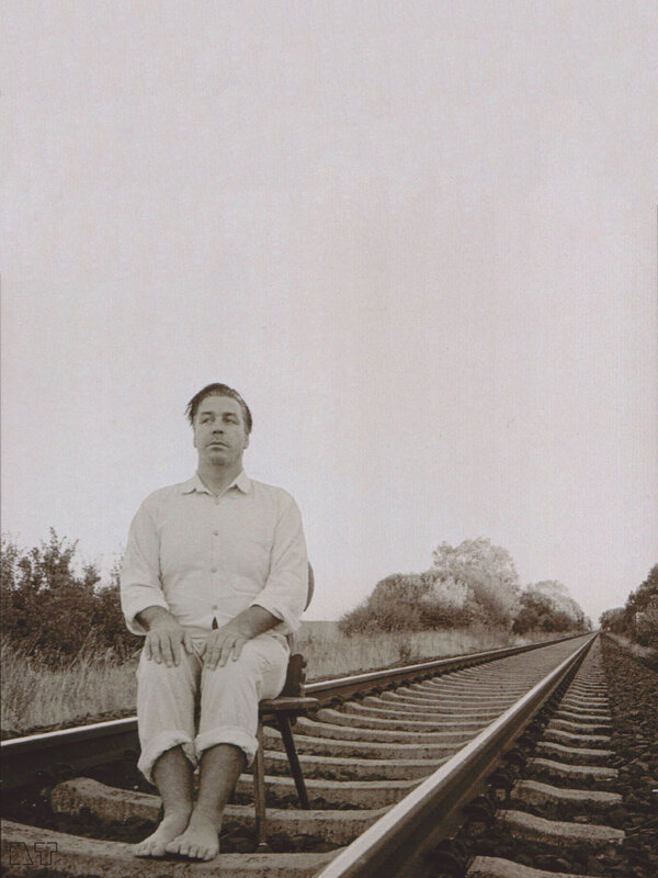man sitting on train tracks