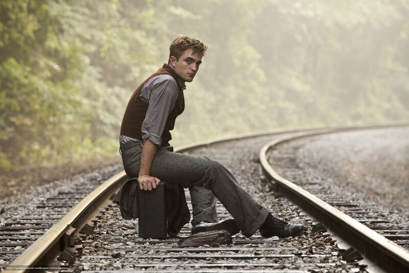 man sitting on train tracks