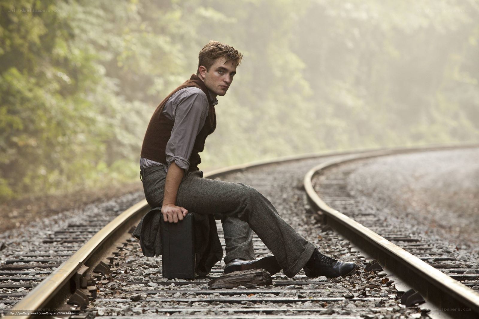 man sitting on train tracks