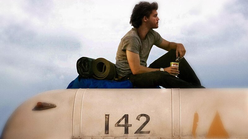 man sitting on vehicle roof
