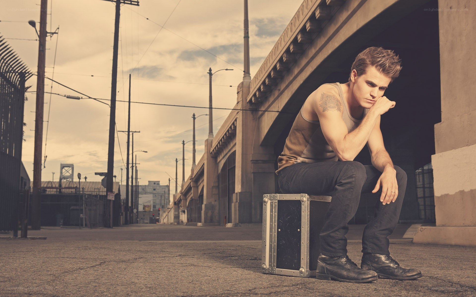 man sitting under a bridge