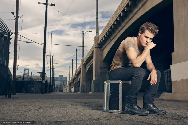 man sitting under a bridge