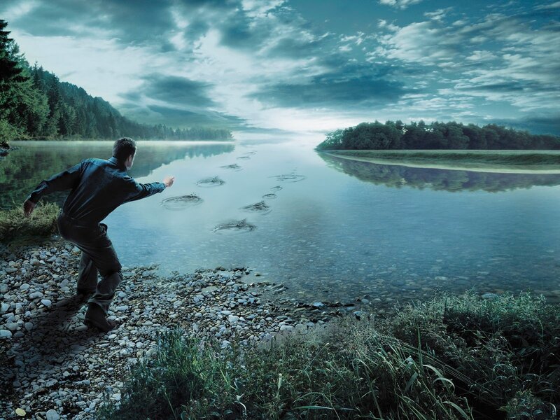 Man skipping stones on a river