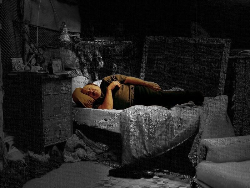 Man sleeping in cluttered room