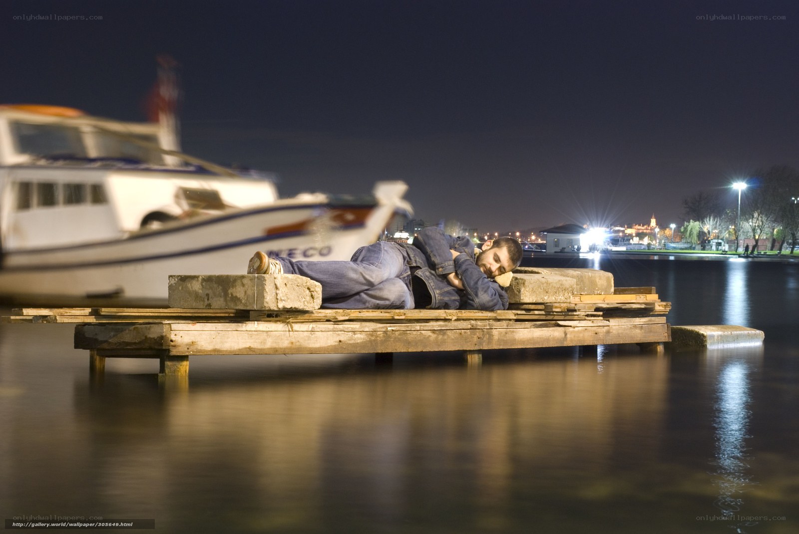 Man sleeping on a dock at night