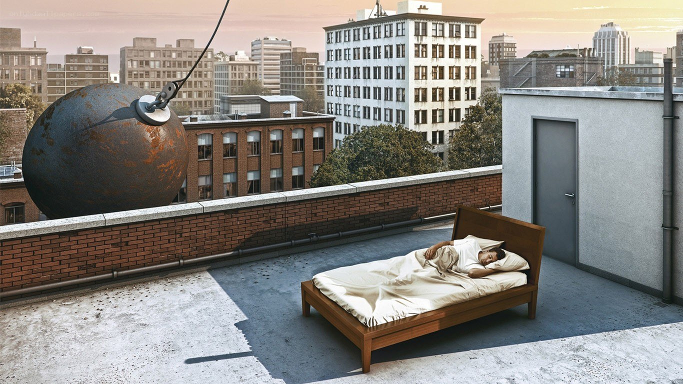 Man sleeping on rooftop with wrecking ball