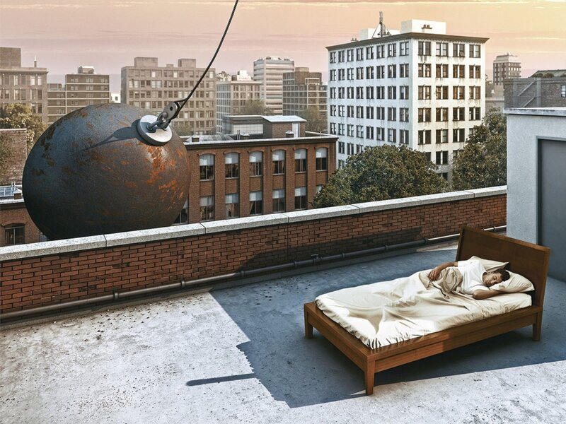 Man sleeping on rooftop with wrecking ball