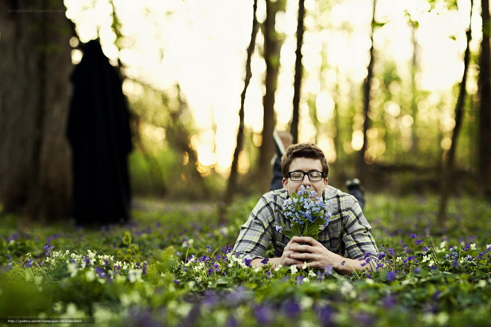 Man smelling flowers in forest
