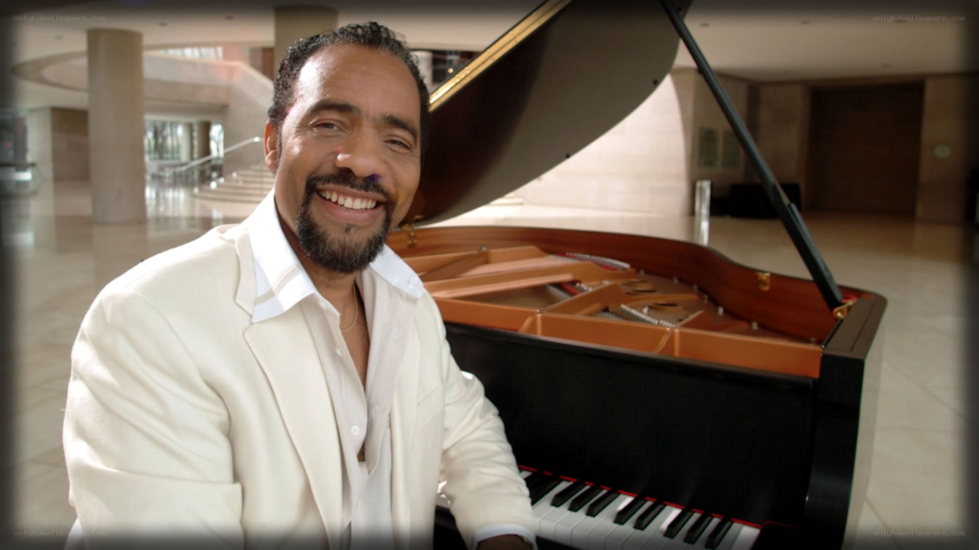 man smiling at piano