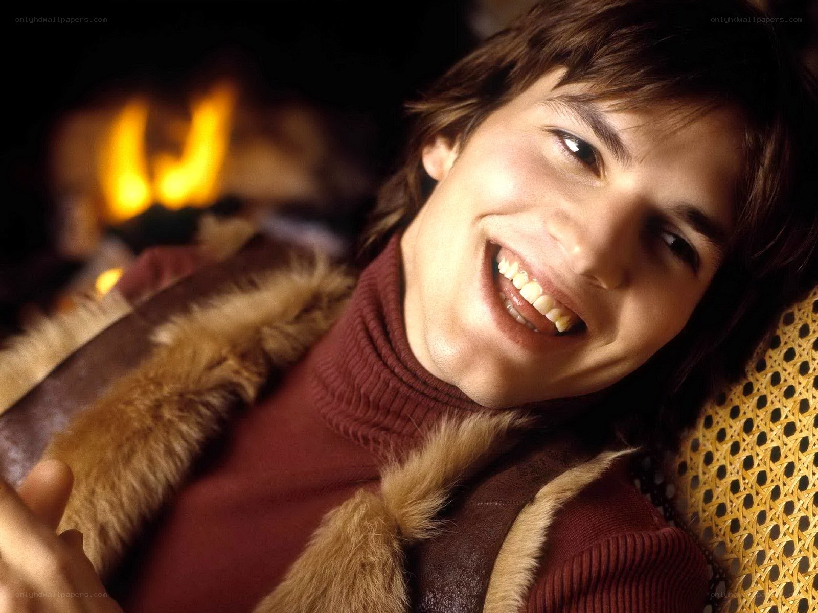 man smiling by fireplace