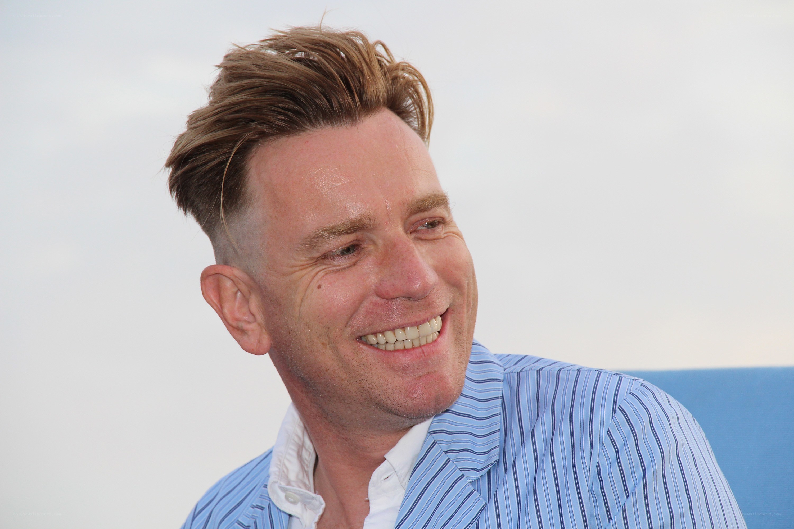 man smiling in blue shirt