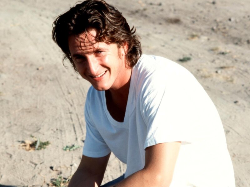 man smiling on sandy ground