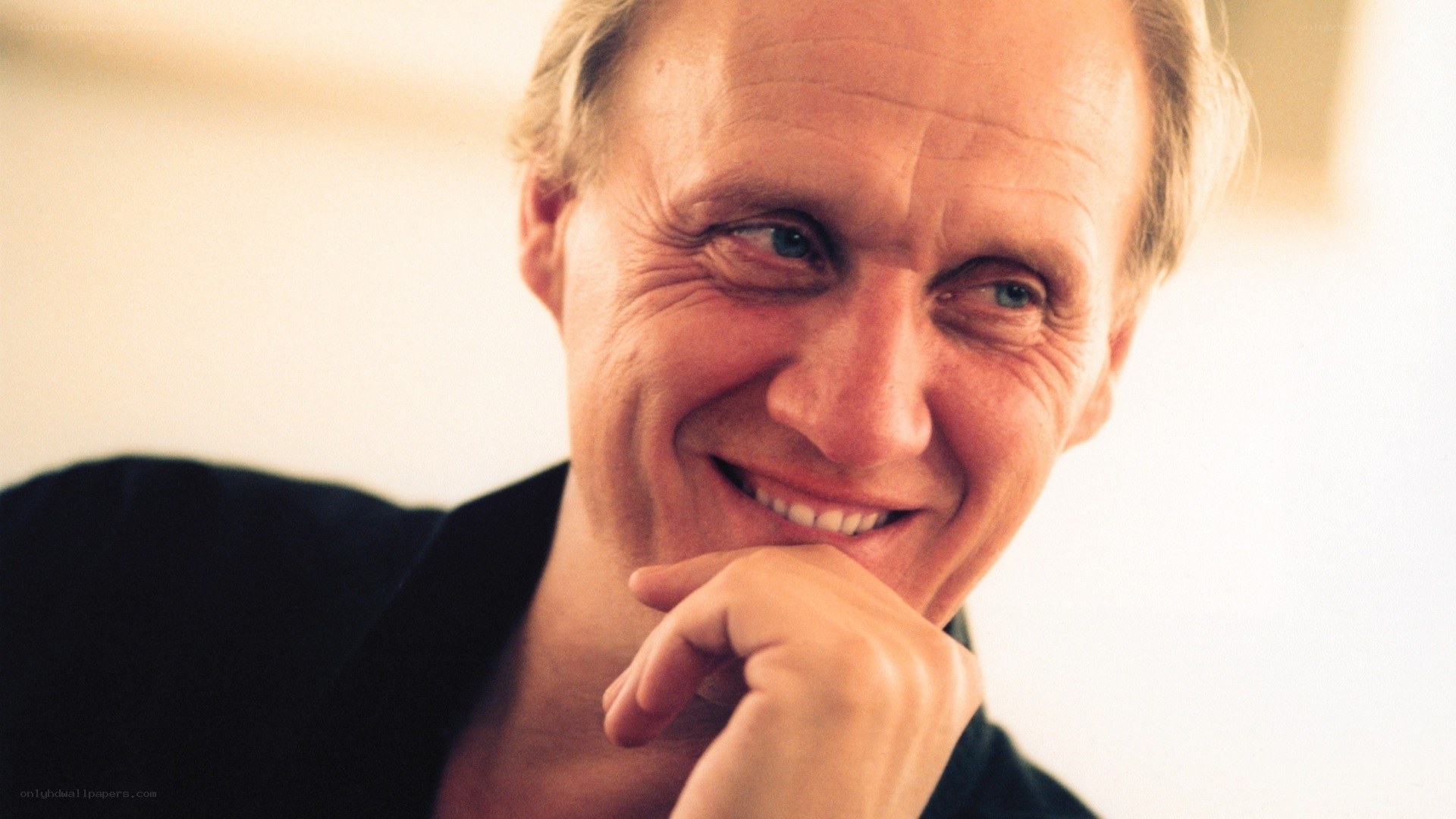 man smiling with hand on chin