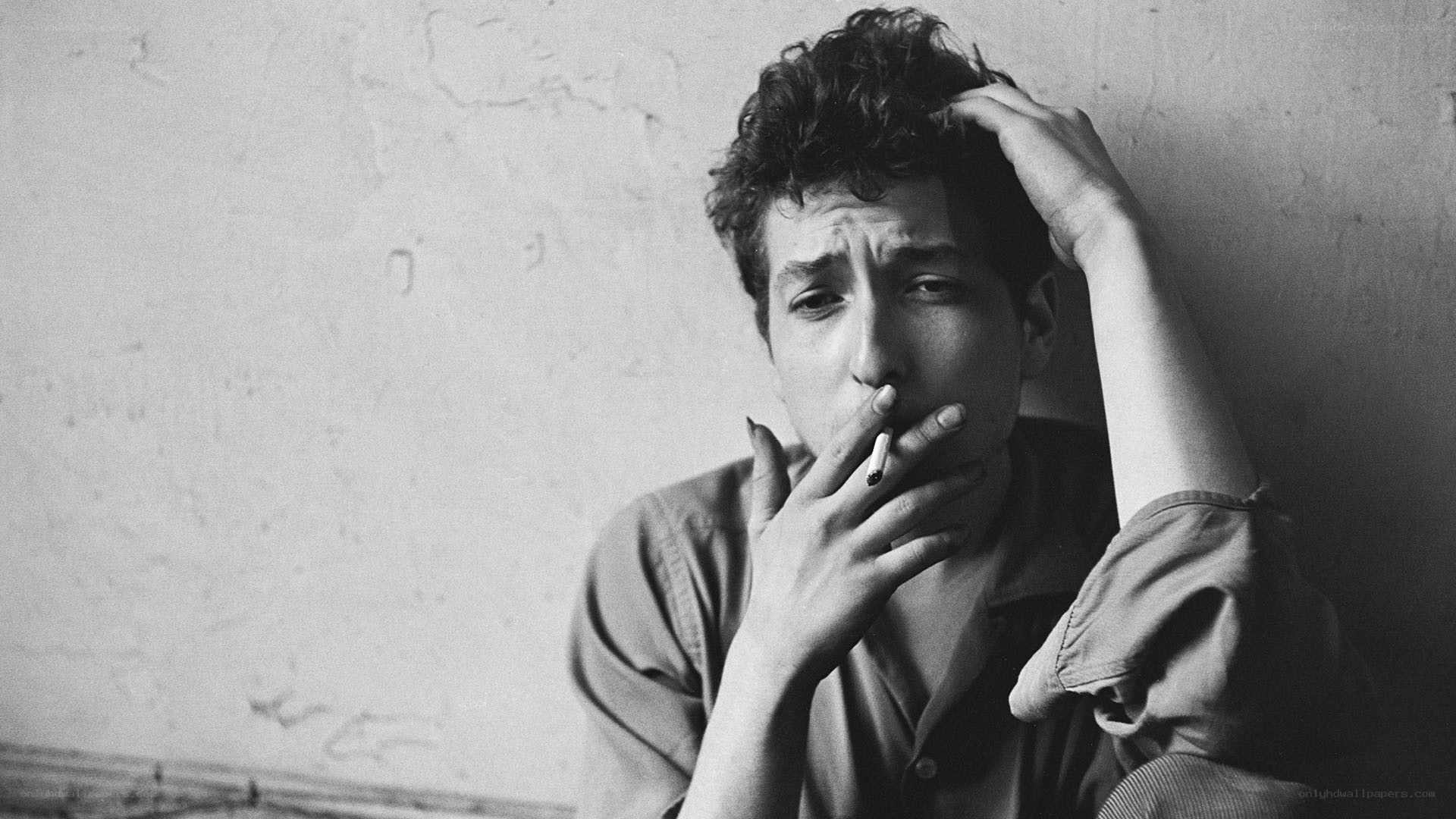 man smoking against wall
